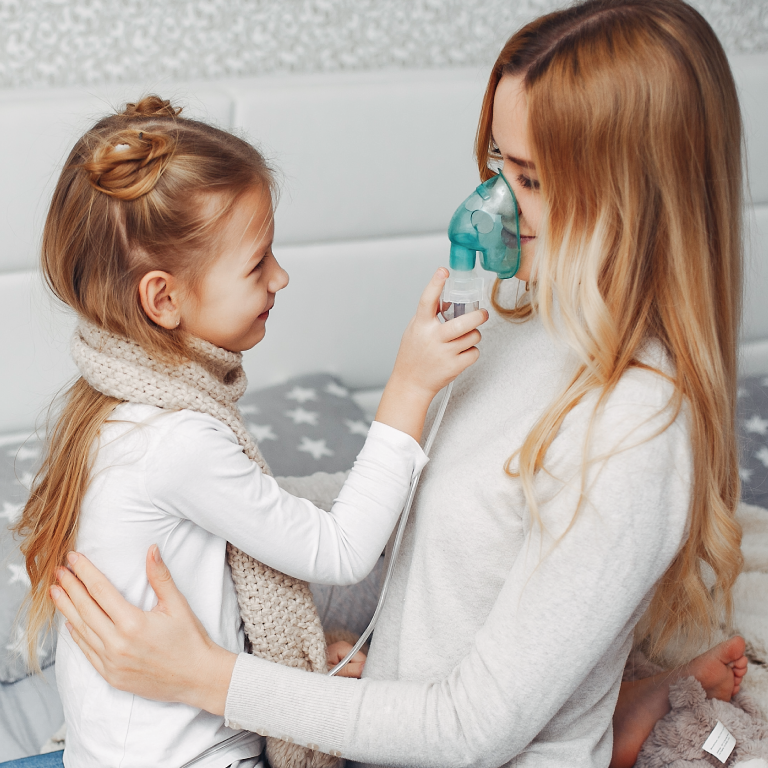 nena jugando con su madre y un nebulizador