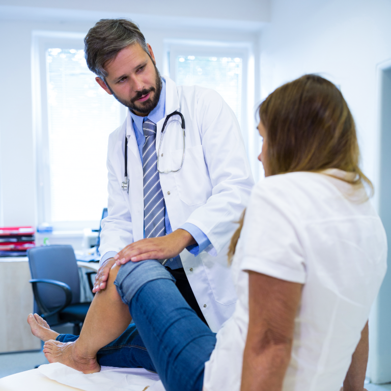 doctor revisando la rodilla de una paciente