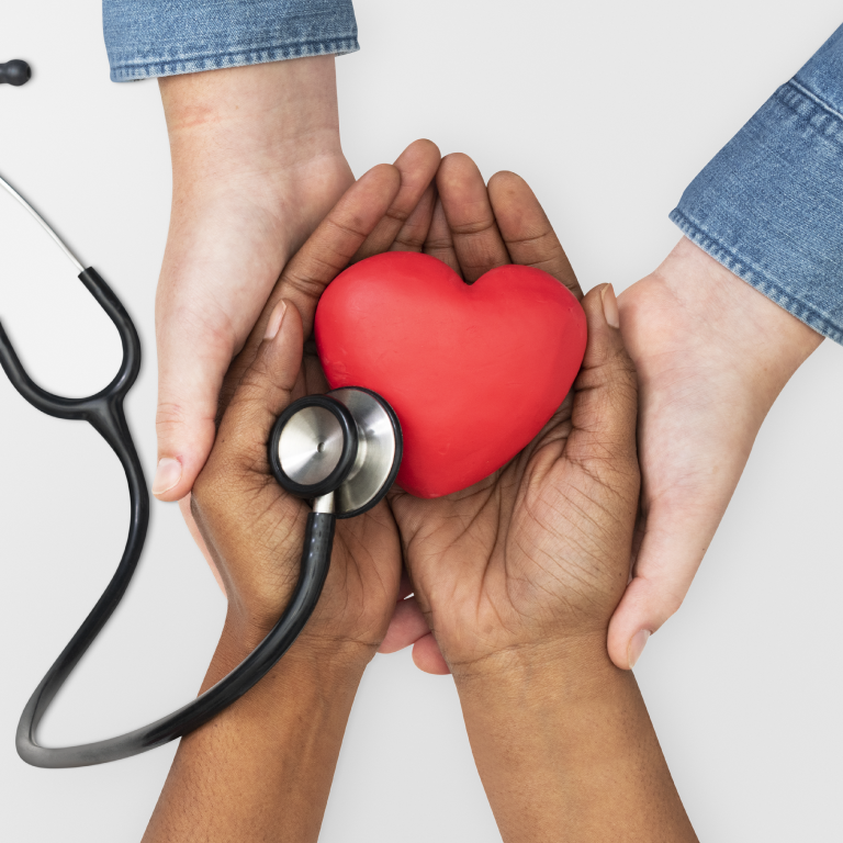 Las manos de dos personas sosteniendo un corazon y un estetoscopio
